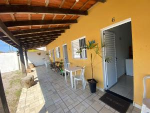 a house with a patio with a table and chairs at Pousada Cauna in Caraguatatuba