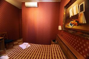 a bedroom with a bed in a room with red wallpaper at Hotel Hollywood in Rome
