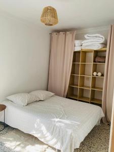 a bedroom with a bed and a shelf with towels at Appartement situé à 200m de la mer in Canet-en-Roussillon