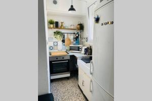 a small kitchen with white cabinets and a stove at Appartement situé à 200m de la mer in Canet-en-Roussillon