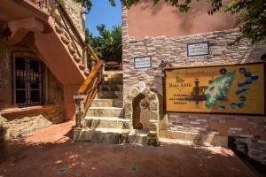 een stenen gebouw met een trap en een bord erop bij Attiki Hotel in Rhodos-stad