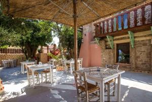 a group of tables and chairs under an umbrella at Attiki Hotel in Rhodes Town