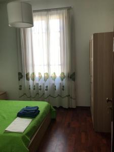 een slaapkamer met een groen bed en een raam bij affittacamere alloggio olivo in Empoli