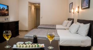a hotel room with two beds and two glasses of wine at Amarea Hotel Acapulco in Acapulco