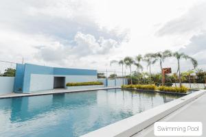 a swimming pool at a resort with palm trees at Quayside Condo near Airport in Mactan