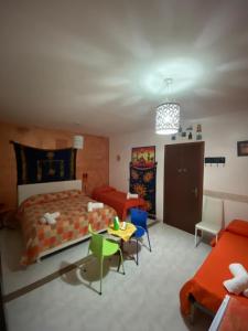 1 dormitorio con 1 cama, mesa y sillas en Colomba Bianca, en Marsala