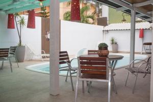 a table and chairs in a room with a pool at Hotel Cravo e Canela in Campos dos Goytacazes
