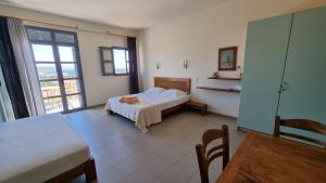 a hotel room with a bed and a window at Domatia me Thea in Elafonisos