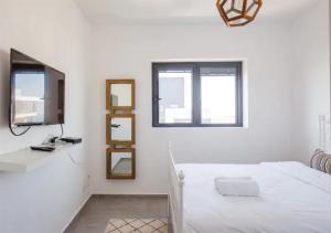 Habitación blanca con cama y espejo en O&O Group- Magical 4BR APT With Panoramic Sea View en Bat Yam