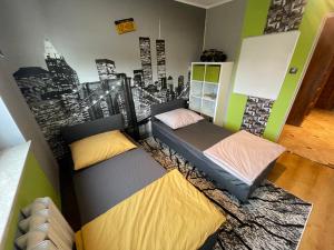 duas camas num quarto com um mural da cidade na parede em Shutter Apartment em Gorzów Wielkopolski