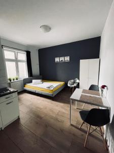 Schlafzimmer mit einem Bett, einem Tisch und Stühlen in der Unterkunft eM Apartment 6 in Kattowitz