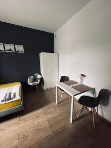 Zimmer mit einem Tisch, Stühlen und einem Bett in der Unterkunft eM Apartment 6 in Kattowitz