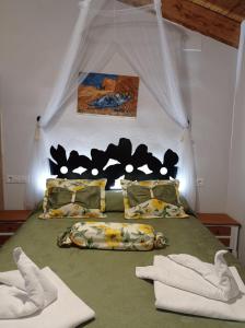 um quarto com uma cama com lençóis e almofadas verdes em Apartamentos CASA RURAL EL VENTANICO em Olocau del Rey