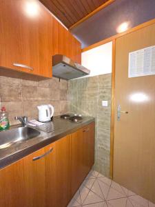 a kitchen with wooden cabinets and a sink and a door at Rubin Jelsa in Jelsa