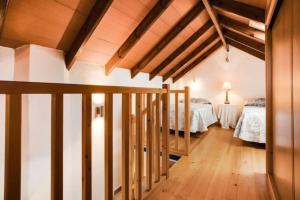 Cette chambre mansardée comprend deux lits et un escalier. dans l'établissement Finca El Altabacar - Casa Rural - Playa, à Mijas