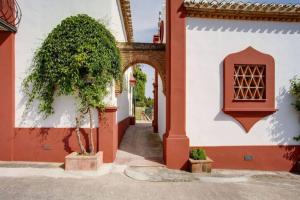 een gebouw met een boog en een boom op een binnenplaats bij Finca El Altabacar - Casa Rural - Playa in Mijas Costa