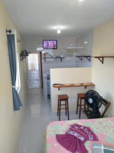 a room with a bed and a kitchen with a table at Kitnet 3,Vista Fantastica in Cabo de Santo Agostinho