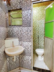 La salle de bains est pourvue d'un lavabo et de toilettes. dans l'établissement Temporada no Atalaia, à Salinópolis