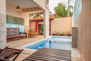 a swimming pool in a house with a patio at Pousada Oásis in Peruíbe