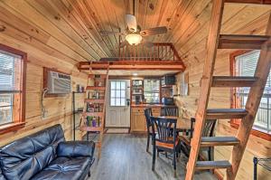 Cabaña de madera con sala de estar y escalera en The Gosling Studio Cabin with River Access!, en New Bern