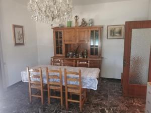 a dining room with a table and a chandelier at Villa Olga - Lunigiana in Filattiera