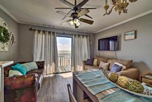 a living room with a couch and a table with a ceiling fan at Oceanfront Corpus Christi Condo Resort Perks! in Corpus Christi