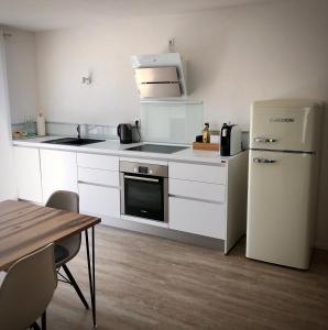 a small kitchen with a refrigerator and a table at Ferienwohnung no.55 in Lörrach