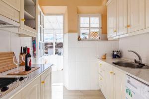 a kitchen with white cabinets and a sink and a window at Casita a la Luz de la Alhambra in Granada