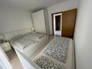 two beds in a small room with a hallway at Tole Villa Podaca in Podaca
