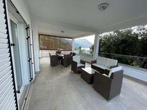 a patio with chairs and tables and large windows at Tole Villa Podaca in Podaca