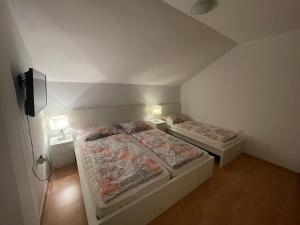 two beds in a room with two lamps and a tv at Tole Villa Podaca 2 with heated Pool in Podaca +46 photos