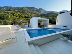 a villa with a swimming pool and a patio at Tole Villa Podaca 2 with heated Pool in Podaca