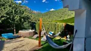 a yard with two hammocks and a hot tub at Casa Tatisita III in Segura de la Sierra