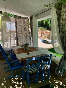 a table and two blue chairs sitting under a tent at Casa Tatisita III in Segura de la Sierra