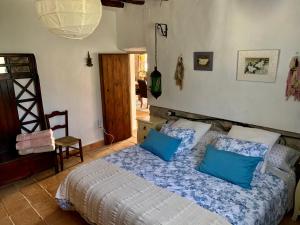 a bedroom with a bed with blue pillows at Casa Tatisita III in Segura de la Sierra