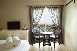 a bedroom with a bed and a table and chairs at Ocean Breeze Boutique Hotel & Marina in Kralendijk