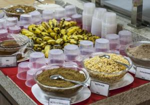 a counter with a bunch of bananas and containers of food at Lacqua Di Roma - SUPER OFERTA in Caldas Novas