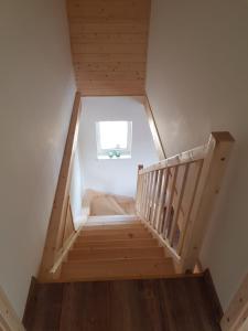 Una escalera de madera en una casa con ventana en Roubenka Strmá en Jeseník