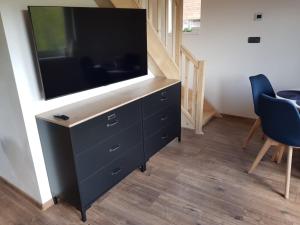 a large flat screen tv on a dresser in a room at Roubenka Strmá in Jeseník
