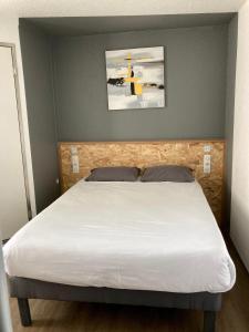 - une chambre dotée d'un lit avec un couvre-lit blanc dans l'établissement Première Classe La Rochelle Sud-Aytré, à Aytré
