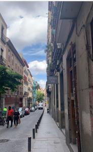 ulica miejska z budynkami i ludźmi idącymi ulicą w obiekcie STAYLISH STUDIO APARTMENT IN MALASANA w Madrycie