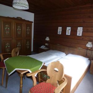 a bedroom with a bed and a table and chairs at Wieselmühle Forellenhof in Grünau im Almtal