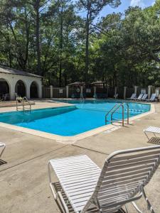 a swimming pool with two chairs and avisorvisor at HHI Homes- Newly Renovated Cozy Modern Pet-Friendly Villa-Ideal Location in Hilton Head Island