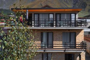 a brick building with a balcony on top of it at Hotel INSIDE Kazbegi in Stepantsminda