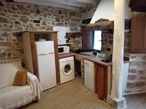 a kitchen with a refrigerator and a washer and dryer at Apartamento La Herrerita in Candelario