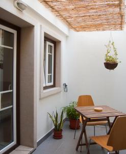 un patio con mesa de madera y sillas en Casa da Tia Matilde, en Sesimbra