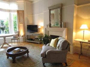 a living room with a chair and a fireplace at Crouch End Apartment - Free Parking in London