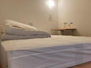 białe łóżko w pokoju ze stołem w obiekcie HOSTEL HIROSAKI - Vacation STAY 66581v w mieście Hirosaki