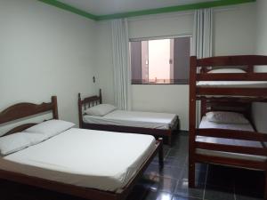 a room with three beds and a window at Casa temporada RA capitolio in Capitólio