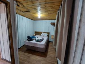 een kleine badkamer met een bed in een kamer bij Morada da Serrinha in Santo Antônio do Pinhal